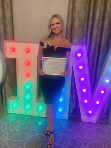 Bryony Dale holding an award certificate