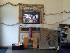 A room decorated with Christmas decorations with a food hamper on the floor