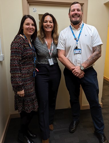 Two women and one man smiling at the camera