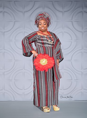 Black woman in traditional clothing smiling at the camera