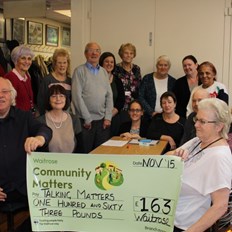 Group of people holding a large donation cheque for £163 from supermarket Waitrose