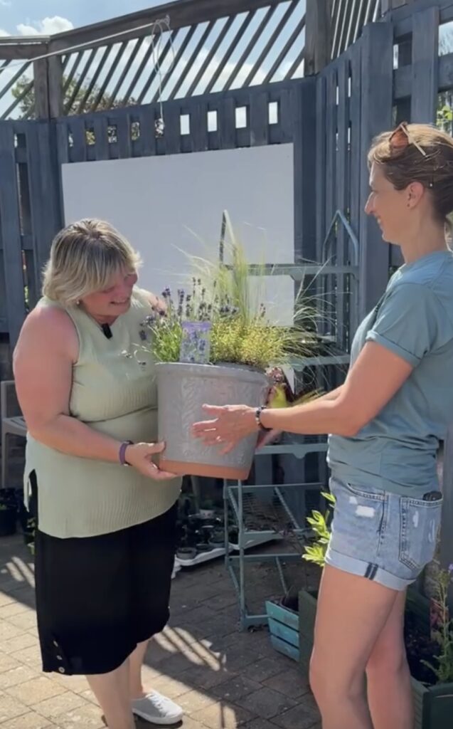 Staff at Poplar holding a plant pot
