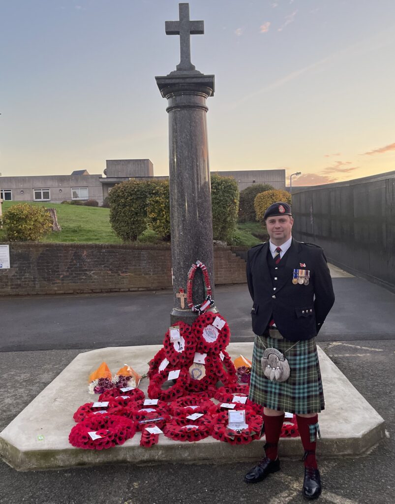 Kevin Russell in ceremonial military dress in front of war memorial