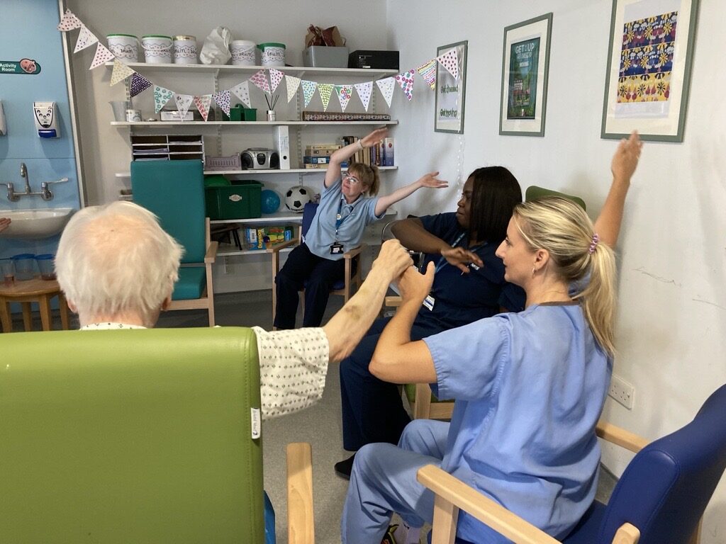 Therapy-staff-with-patients-take-part-in-a-music-and-singing-session-on-Plane-Ward