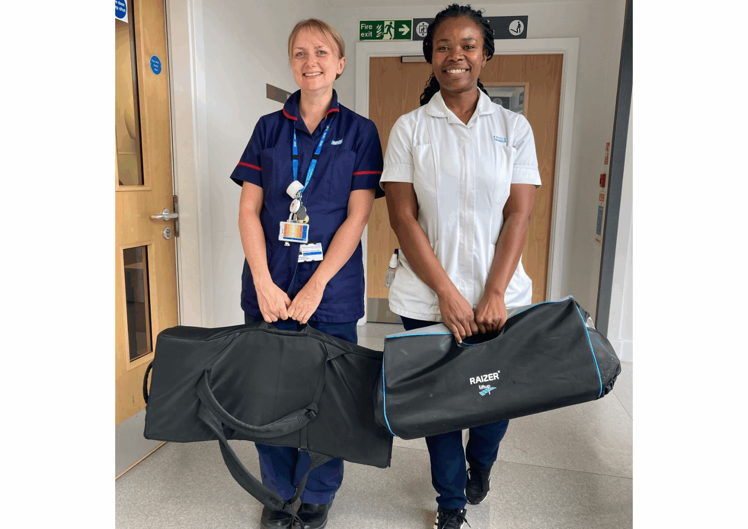 Two women in clinical uniforms holding duffel bags.