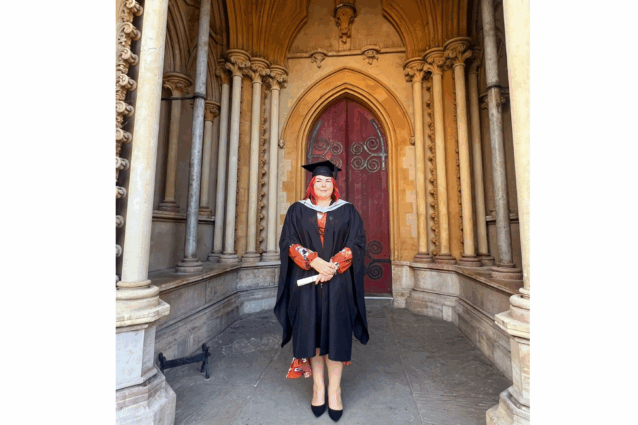 Photograph of Pamela Stevens wearing her graduation gown and at.