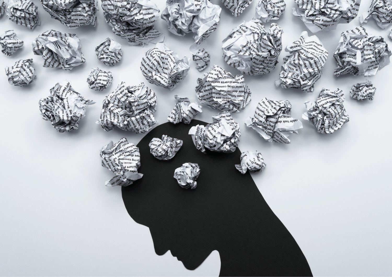 Black silhouette of a head with scrunched of bits of paper coming out of its head. This is to represent all the different scattered thoughts.