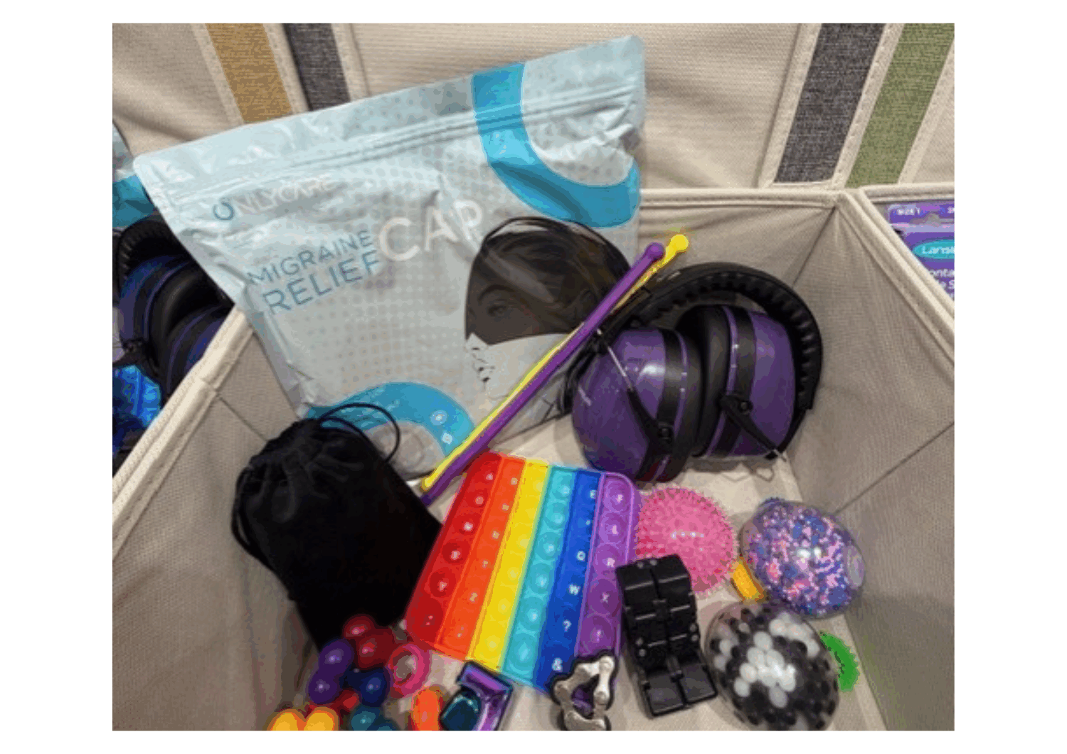 Photograph of things found in a sensory box; fidget toys, migraine relief caps, sensory balls and games, and mood lamps.
