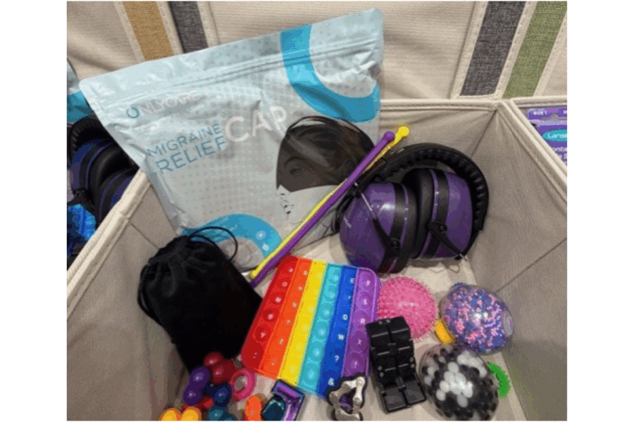 Photograph of things found in a sensory box; fidget toys, migraine relief caps, sensory balls and games, and mood lamps.
