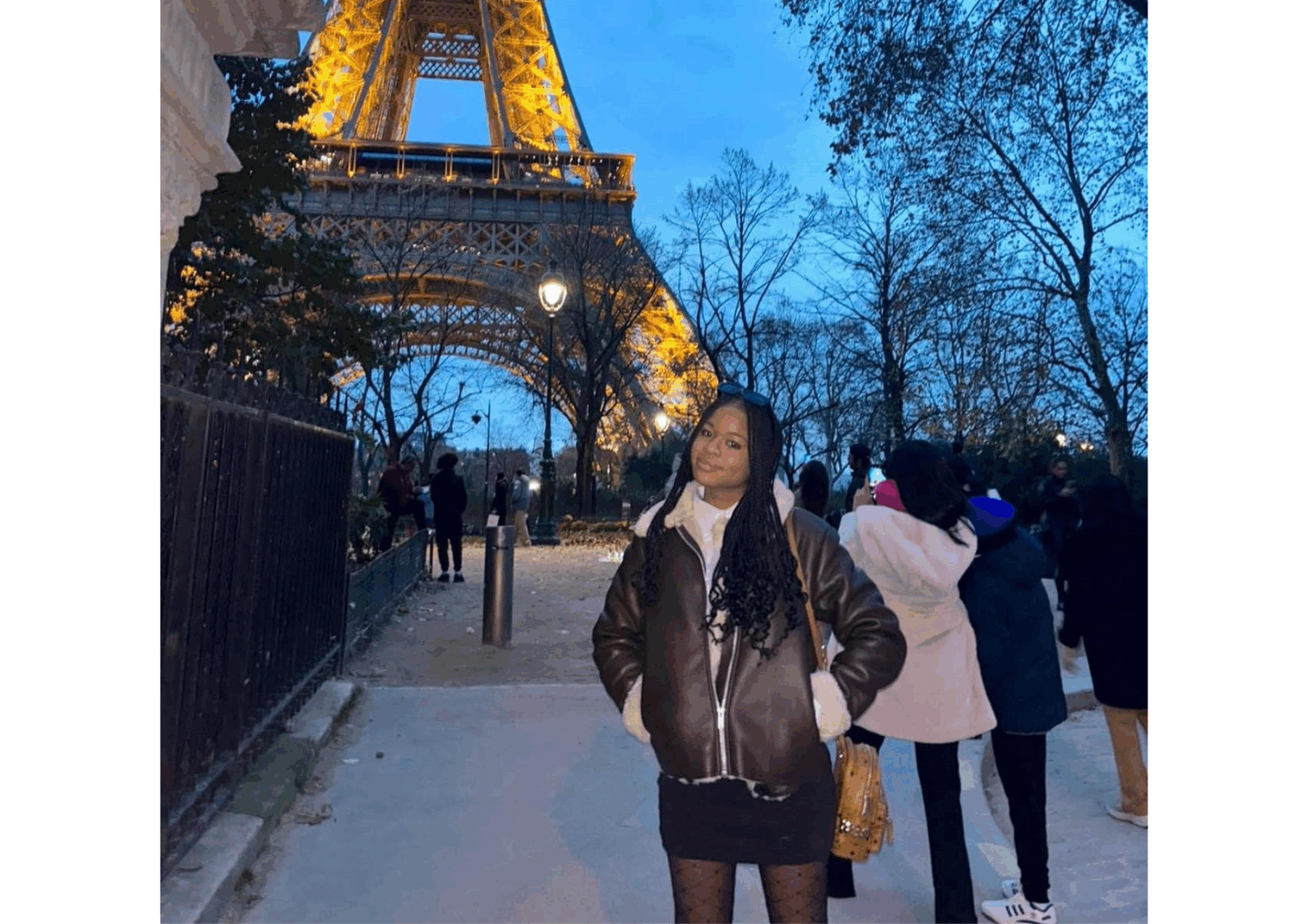 Photograph of April Longe standing in from of the Eiffel Tower.