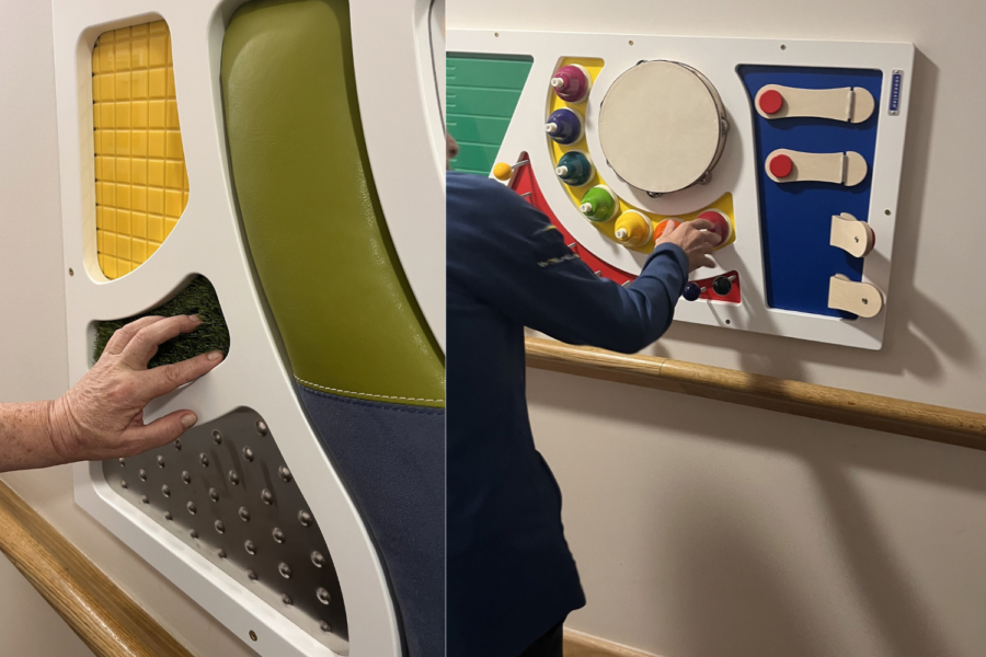 Left side: A tactile panel featuring sections with different textures, including yellow tiles, soft green padding, faux grass, and a metallic surface with raised studs. A hand is reaching out to touch the faux grass section. Right side: An interactive musical panel featuring colorful bells, a mini tambourine, switches, and buttons. A person in a blue long-sleeved shirt is shown interacting with the red button under the bells.