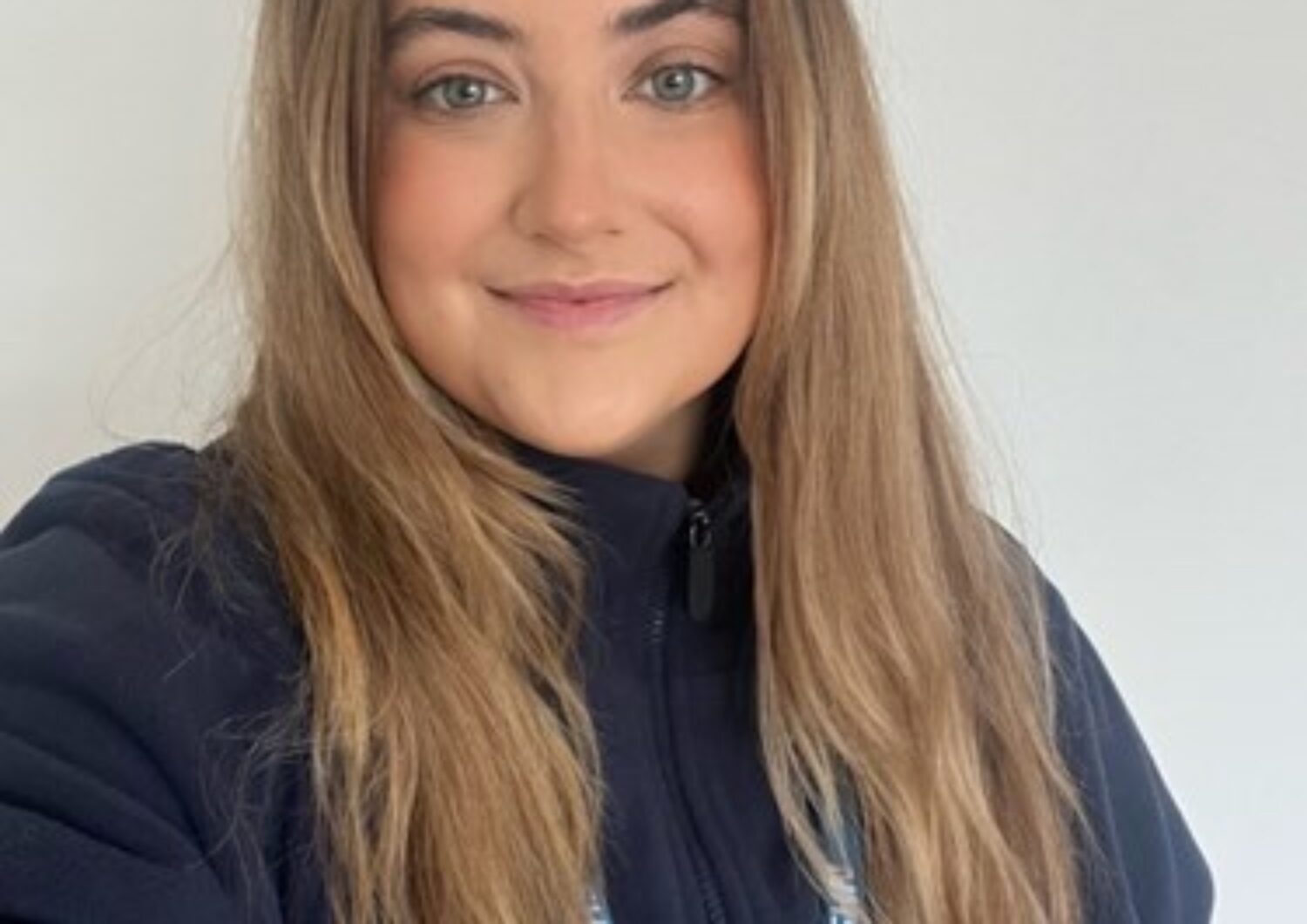 Young woman with long brown hair smiling at the camera
