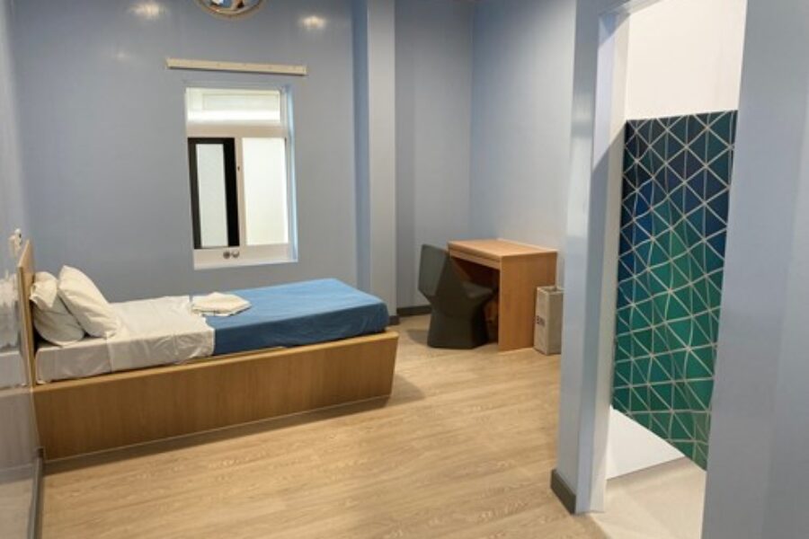 Inpatient ward bedroom with a bed, desk and ensuite bathroom