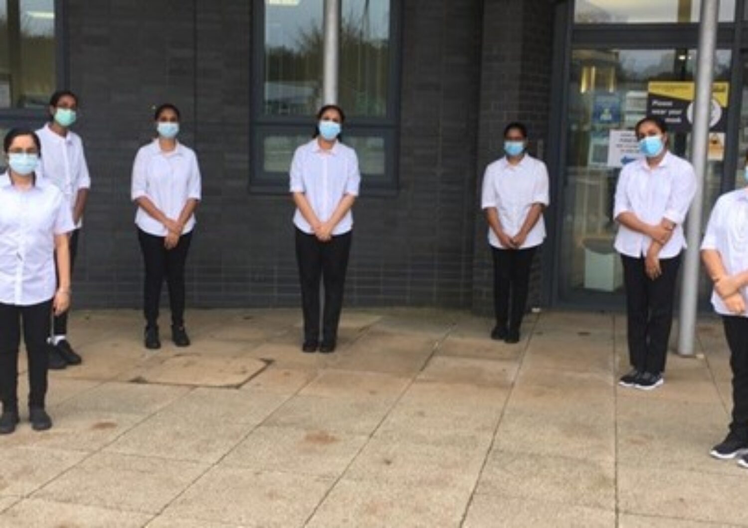 Indian nurses who joined the Trust, having their photo taken outside of St Margaret's Hospital.