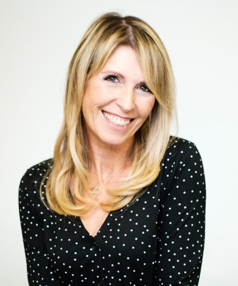 Photo of Alex green wearing a black top with white dots