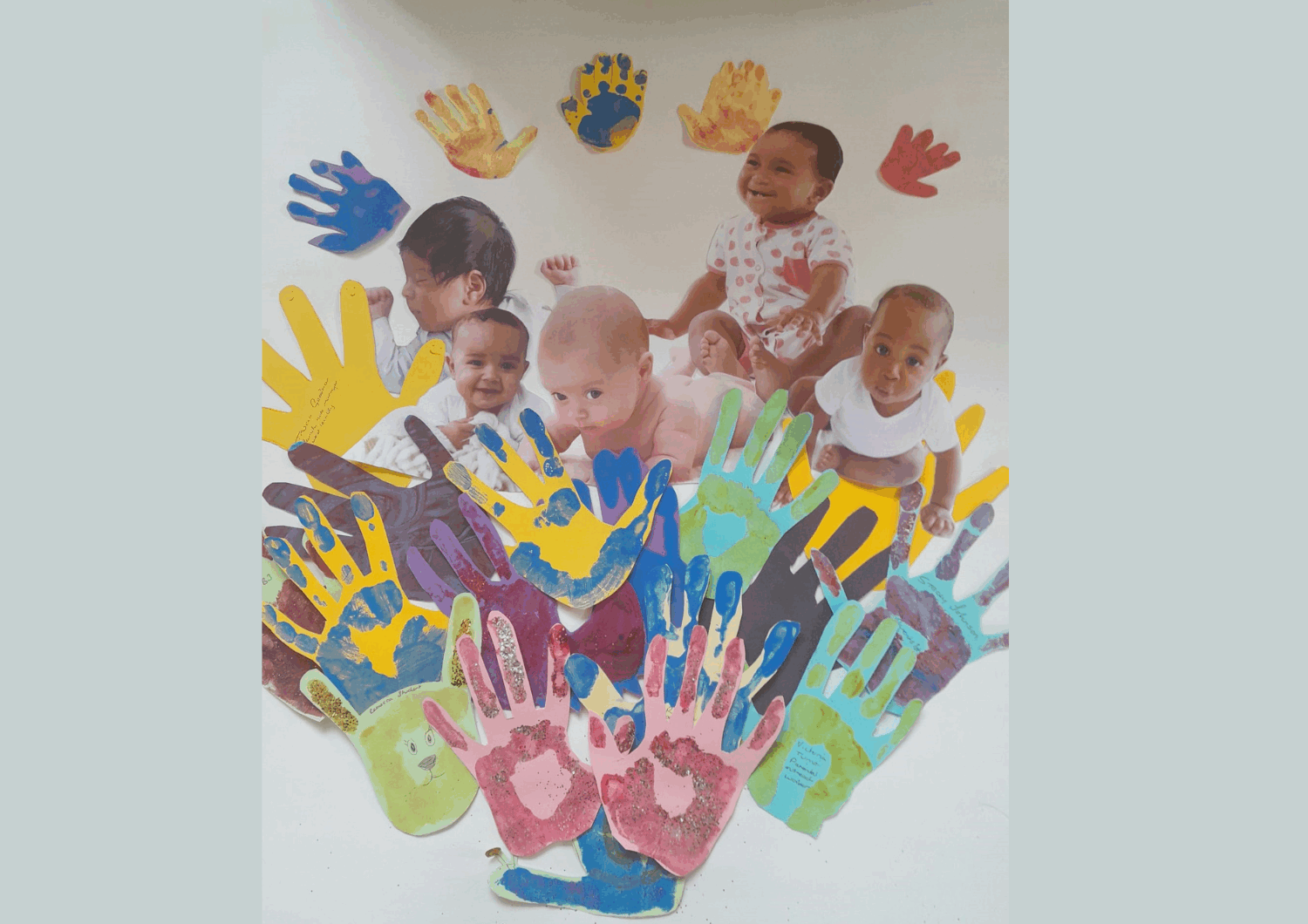Picture of babies surrounded by hand prints.