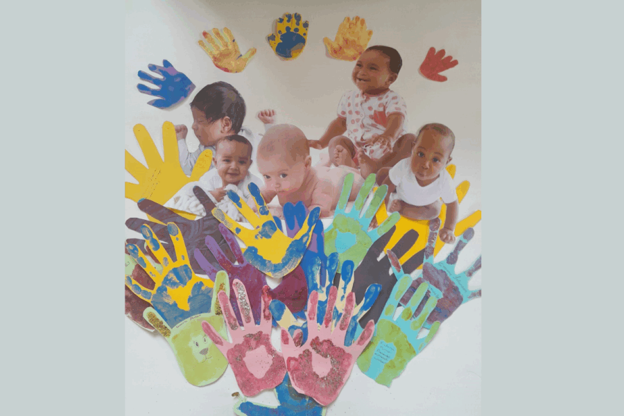 Picture of babies surrounded by hand prints.