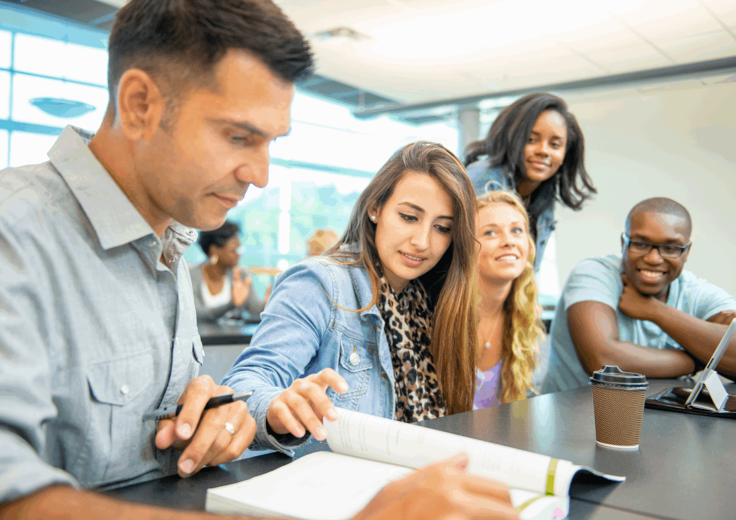 Group of adult students looking at a book