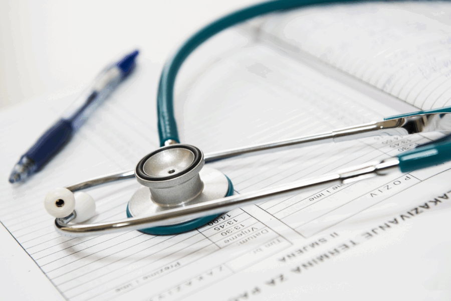 Photo with a stethoscope and pen on top of an appointment book.