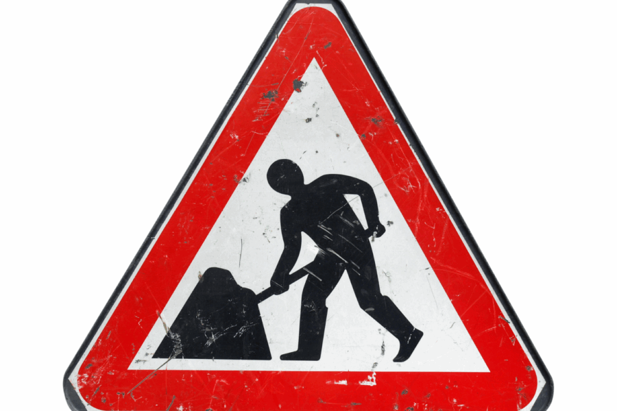 Triangle with a red border and an image of a stick man digging to represent roadworks in progress.
